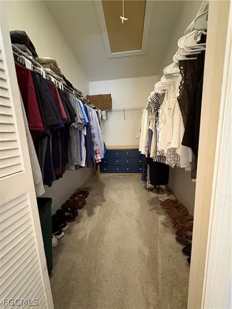 a view of walk in closet with clothes and shoes