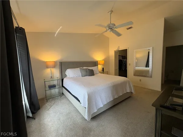 a bedroom with a bed and a flat tv screen on a dresser