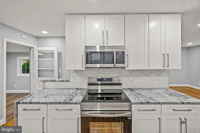 a kitchen with granite countertop a stove sink and cabinets