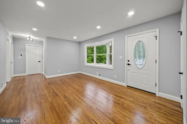 an empty room with wooden floor and window