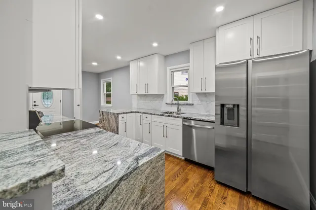 a kitchen with stainless steel appliances granite countertop a refrigerator sink and cabinets