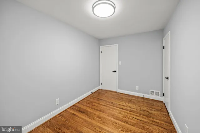 a view of a room with wooden floor and white walls