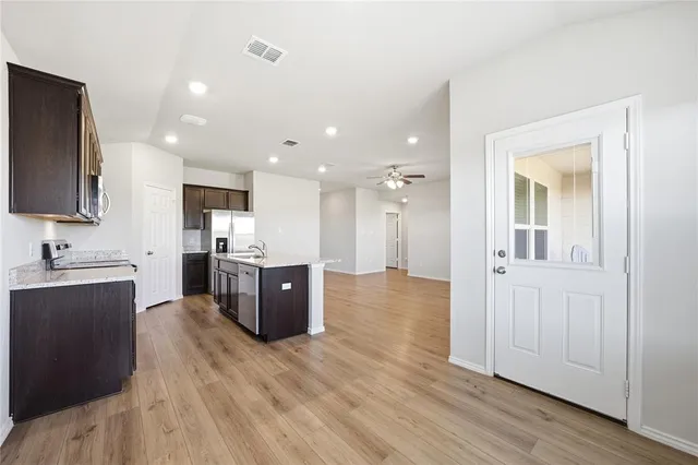a large kitchen with stainless steel appliances lots of counter space and wooden floor