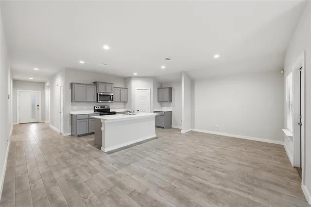 a large white kitchen with a refrigerator a sink and a stove top oven