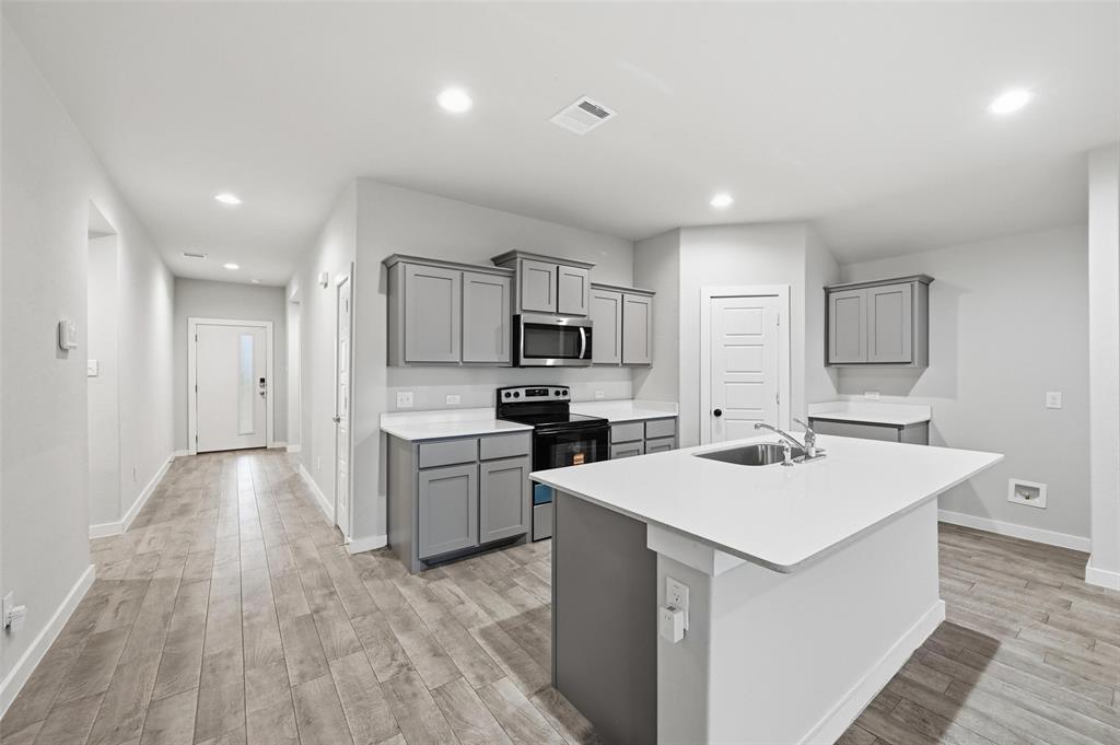 701 Griffith Pk Trail Alvarado, TX 76009 - Photo 5 of 20 a kitchen with a sink white cabinets and stainless steel appliances