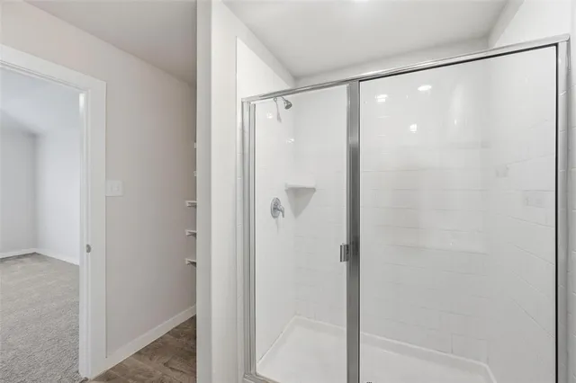 a bathroom with a glass shower door and a shower