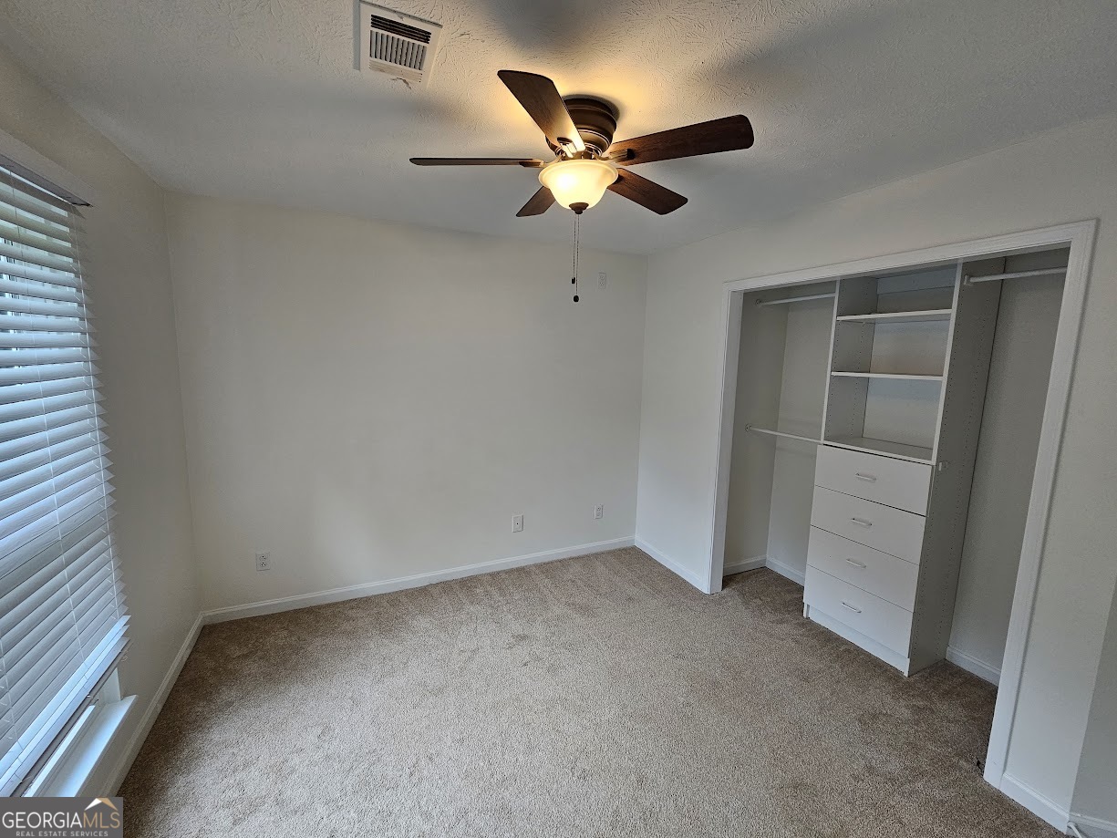 65 Tralee Trace Sharpsburg, GA 30277 - Photo 9 of 21 an empty room with closet and fan