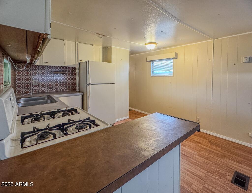 11100 West Alsdorf Road, Unit 10 Arizona City, AZ 85123 - Photo 12 of 19 a kitchen with a wooden floor and a stove top oven