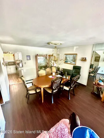 a kitchen with stainless steel appliances granite countertop a sink dishwasher a stove and white cabinets with wooden floor