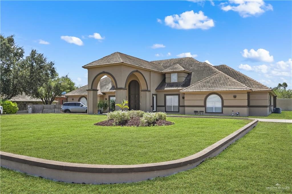 800 East Mile 3 Road Mission, TX 78573 - Photo 1 of 45 View of front of house with stucco siding and a front lawn