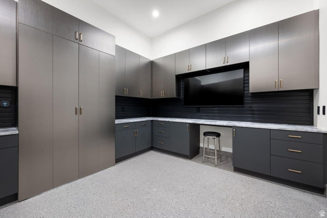 2867 East Granite Way St. George, UT 84790 - Photo 36 of 69 Custom storage system featuring extensive cabinetry, integrated workspace, durable epoxy flooring, and full-height built-in units
