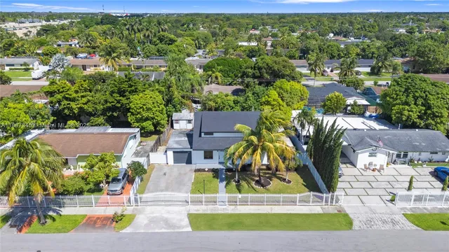 an aerial view of residential houses with yard and swimming pool