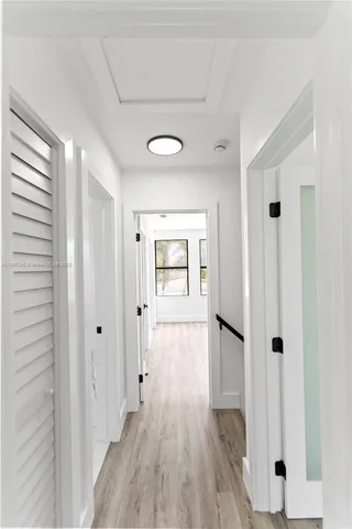 a view of a hallway with wooden floor and closet area