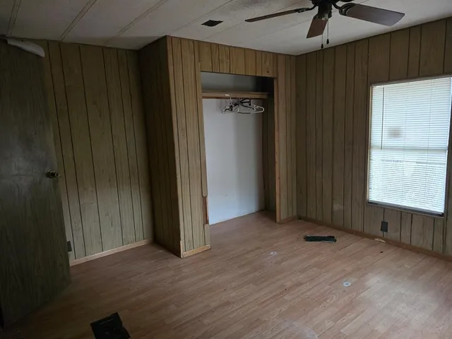 an empty room with closet and windows