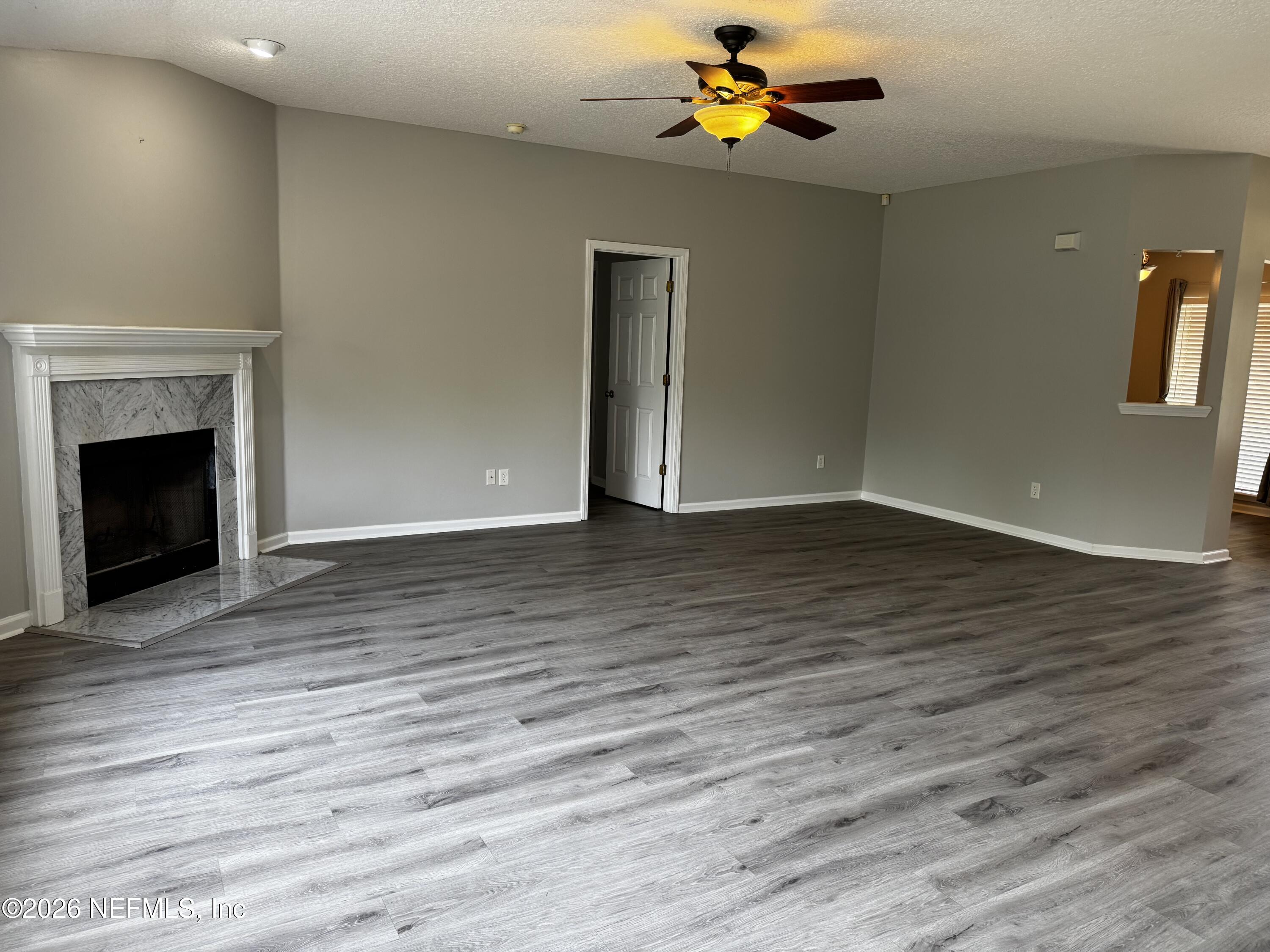 16255 Shellcracker Road Jacksonville, FL 32226 - Photo 10 of 40 a view of an empty room with wooden floor and a fireplace