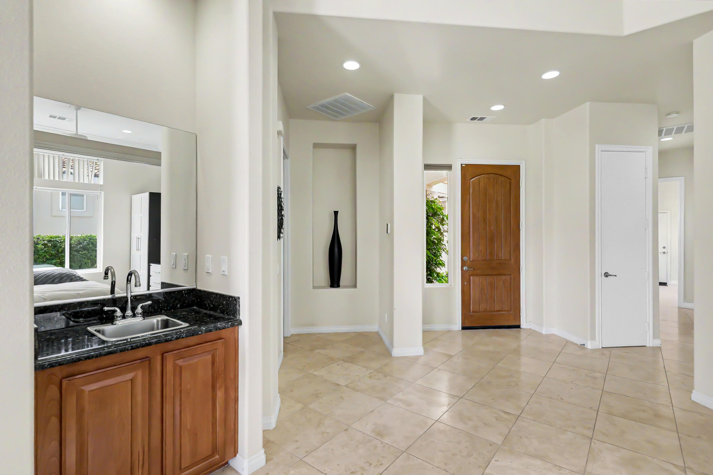 54048 Riviera La Quinta, CA 92253 - Photo 6 of 39 a bathroom with a granite countertop sink a mirror and a shower