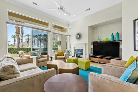 a living room with stainless steel appliances furniture a rug and a view of kitchen