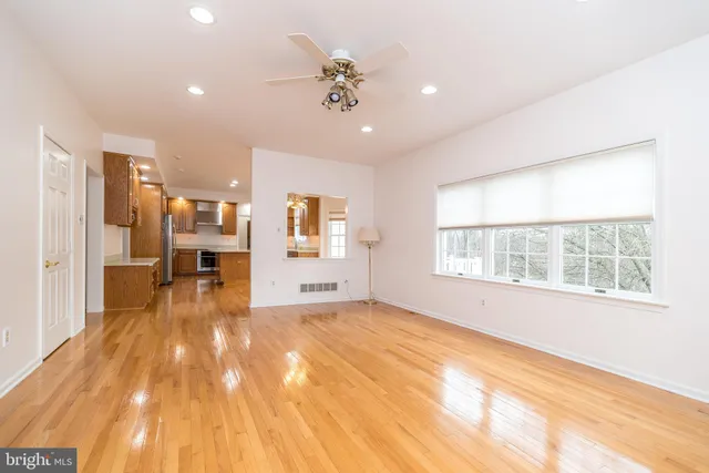a view of empty room with wooden floor and a fireplace