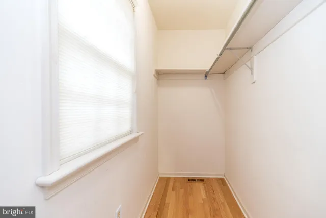 a view of an empty room with windows & stairs