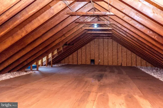 an empty room with chandelier fan and windows