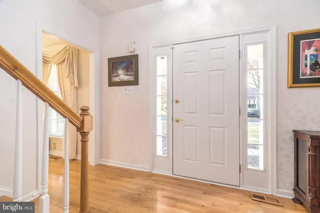 a view of staircase with wooden floor and white walls