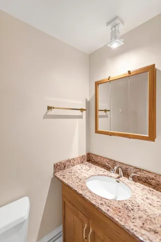 a bathroom with a granite countertop sink and a mirror