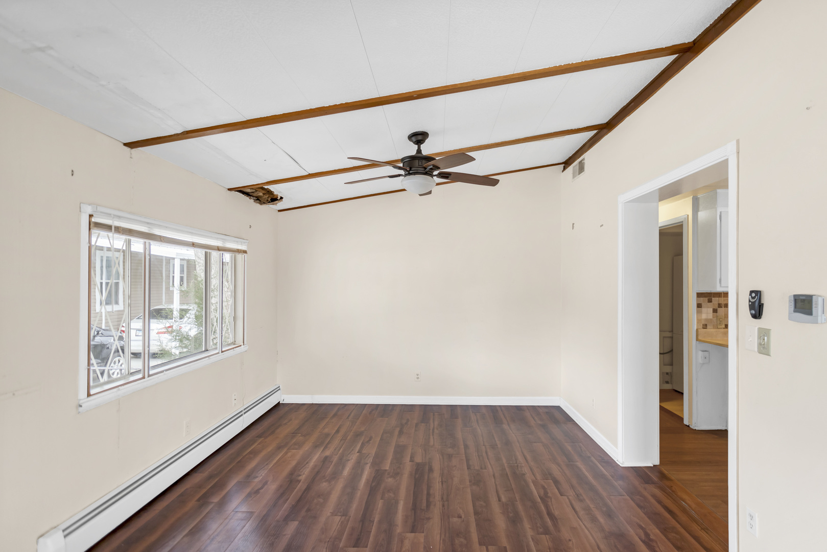 1053 Lakeview Road Elgin, IL 60123 - Photo 9 of 33 a view of an empty room with wooden floor and a window
