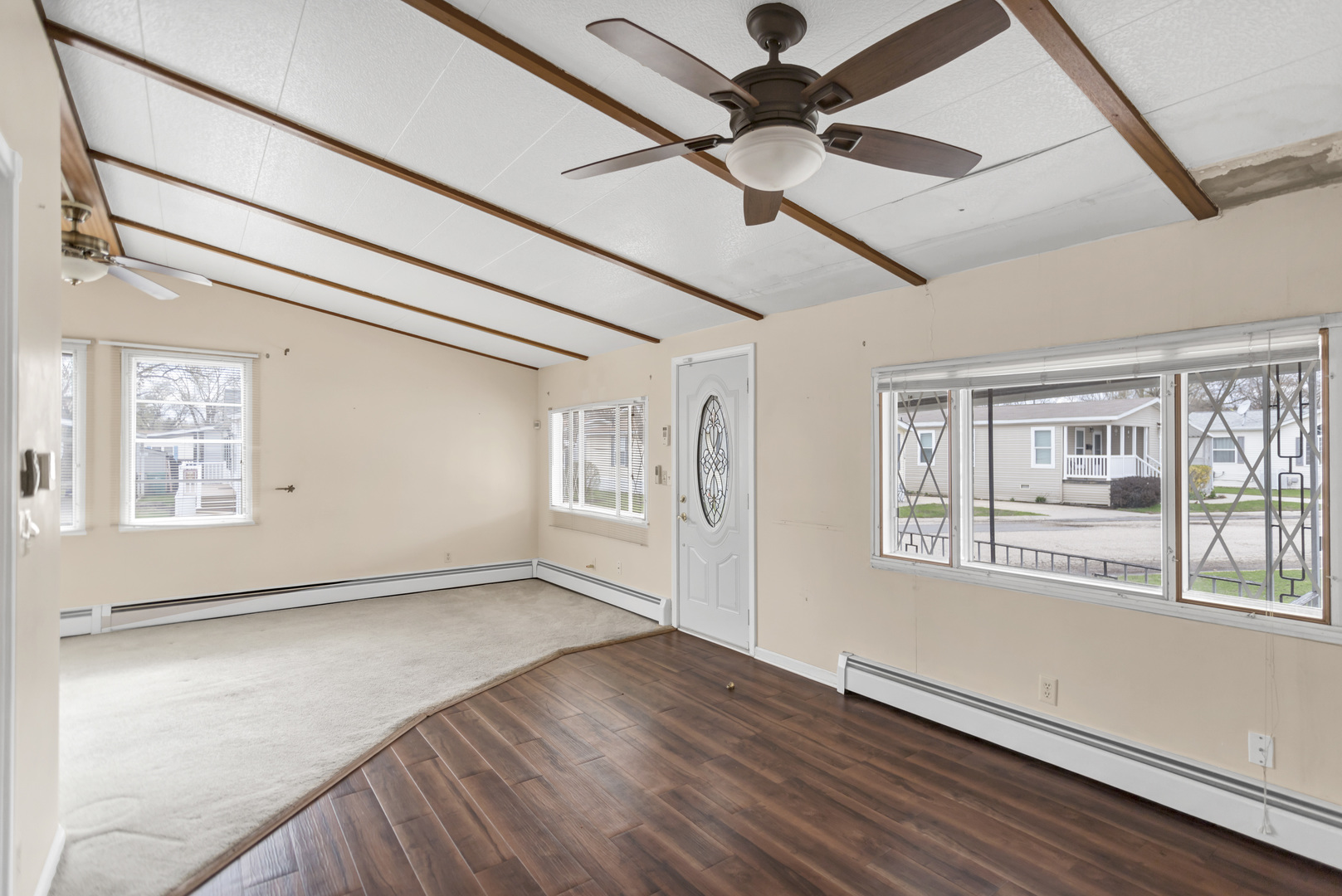 1053 Lakeview Road Elgin, IL 60123 - Photo 10 of 33 an empty room with wooden floor fan and windows