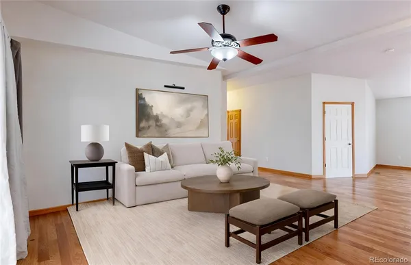 a living room with furniture and a wooden floor