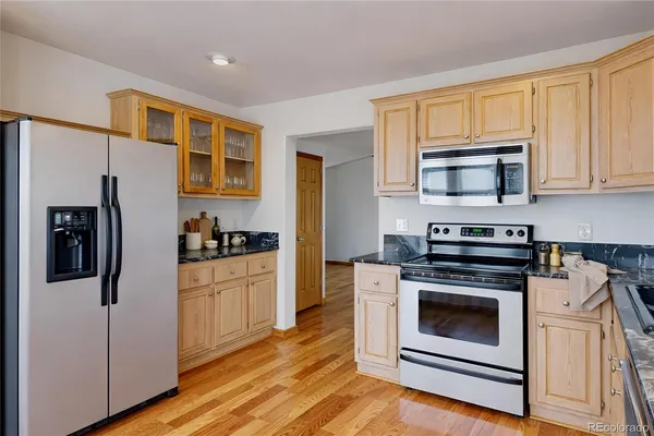 a kitchen with stainless steel appliances granite countertop a stove a refrigerator and a microwave