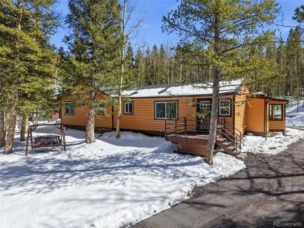 a view of a house with a yard siting area and covered with snow