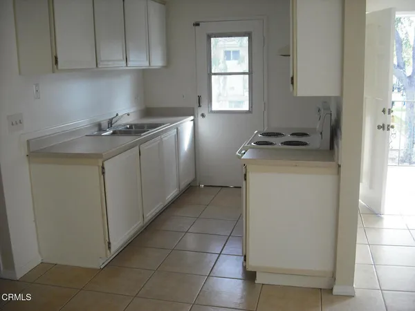 a kitchen with a sink a stove and cabinets