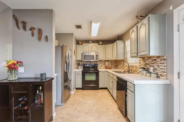 a kitchen with stainless steel appliances granite countertop a refrigerator and a sink