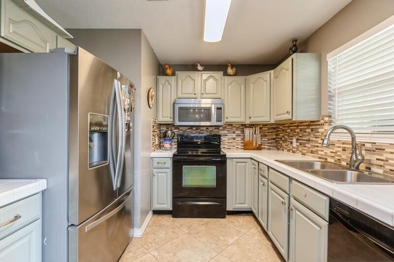 2377 Lake Silver Road Crestview, FL 32536 - Photo 19 of 36 a kitchen with stainless steel appliances granite countertop a refrigerator and a sink