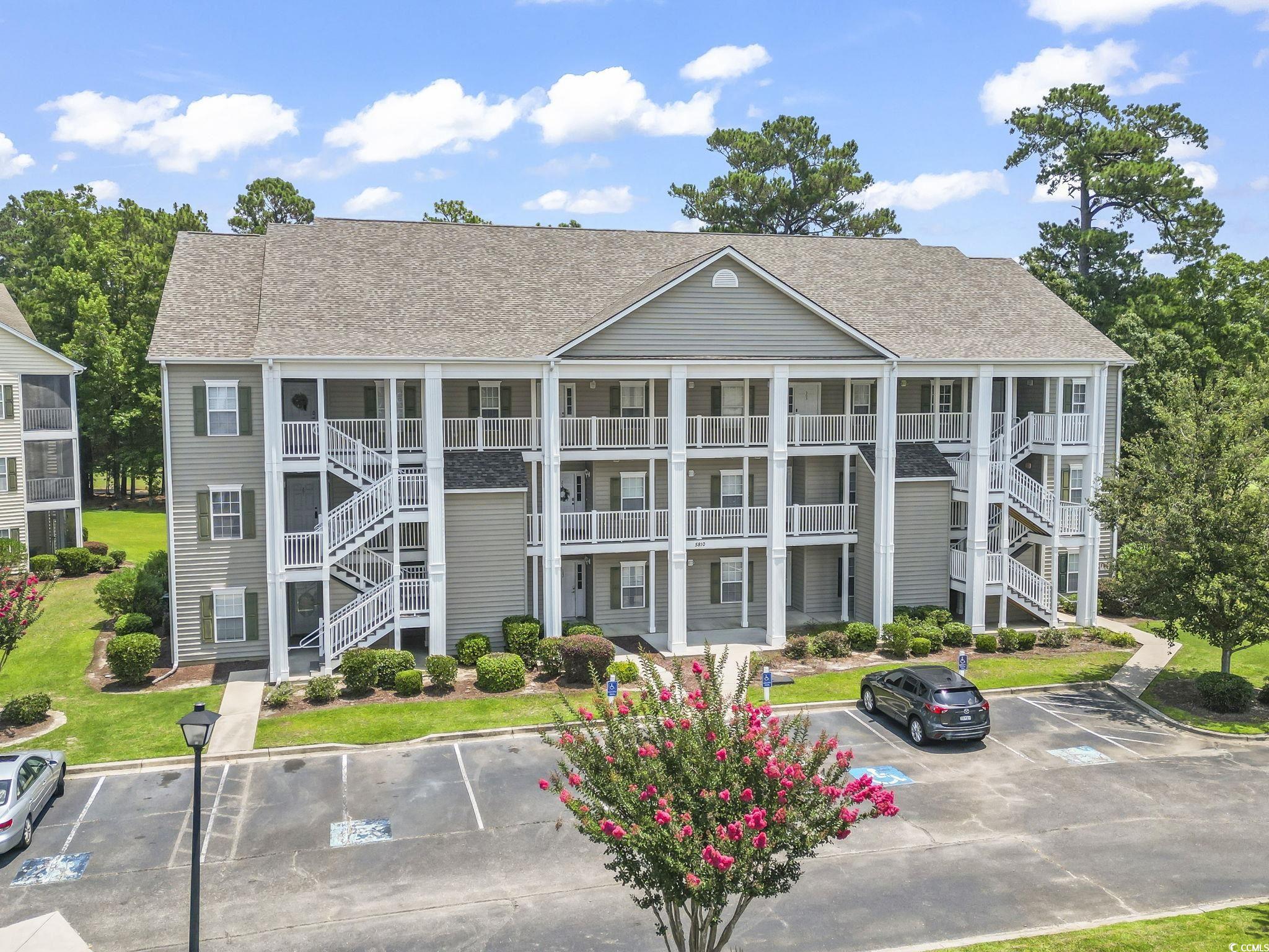 View of property featuring uncovered parking