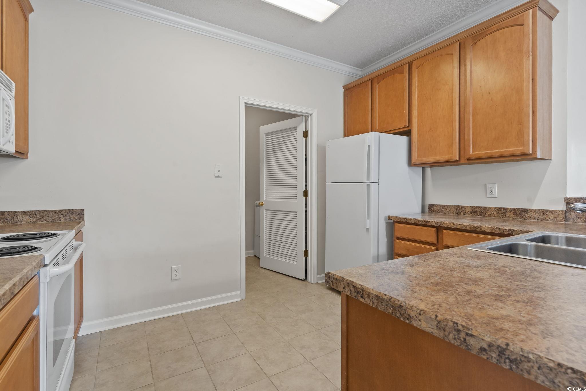 5810 Longwood Drive, Unit 14304 Murrells Inlet, SC 29576 - Photo 13 of 30 Kitchen with white appliances, crown molding, ligh