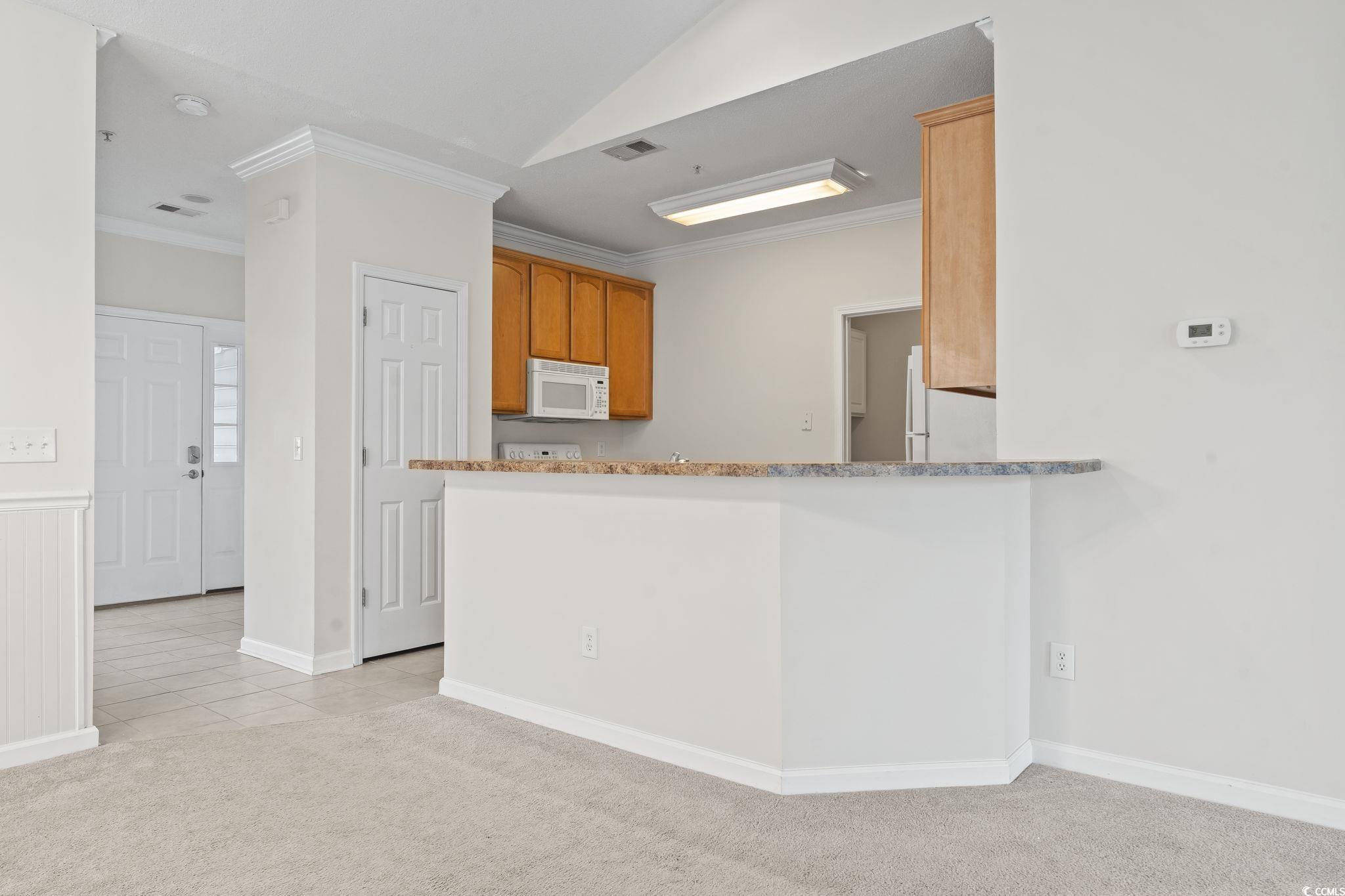 5810 Longwood Drive, Unit 14304 Murrells Inlet, SC 29576 - Photo 17 of 30 Kitchen with white appliances, ornamental molding,