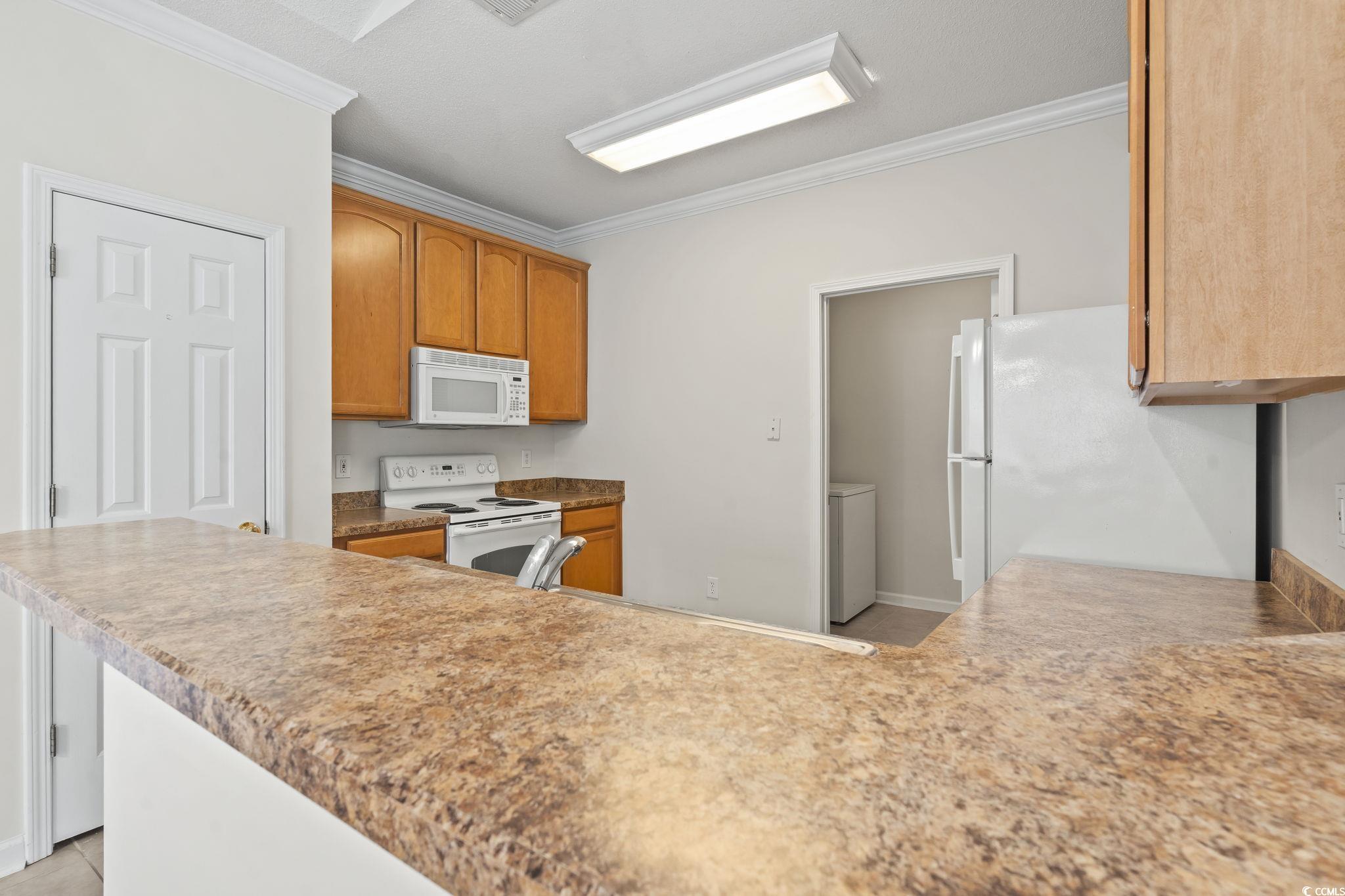 5810 Longwood Drive, Unit 14304 Murrells Inlet, SC 29576 - Photo 18 of 30 Kitchen with white appliances, ornamental molding,