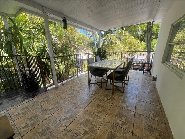 a dining room with furniture and large windows