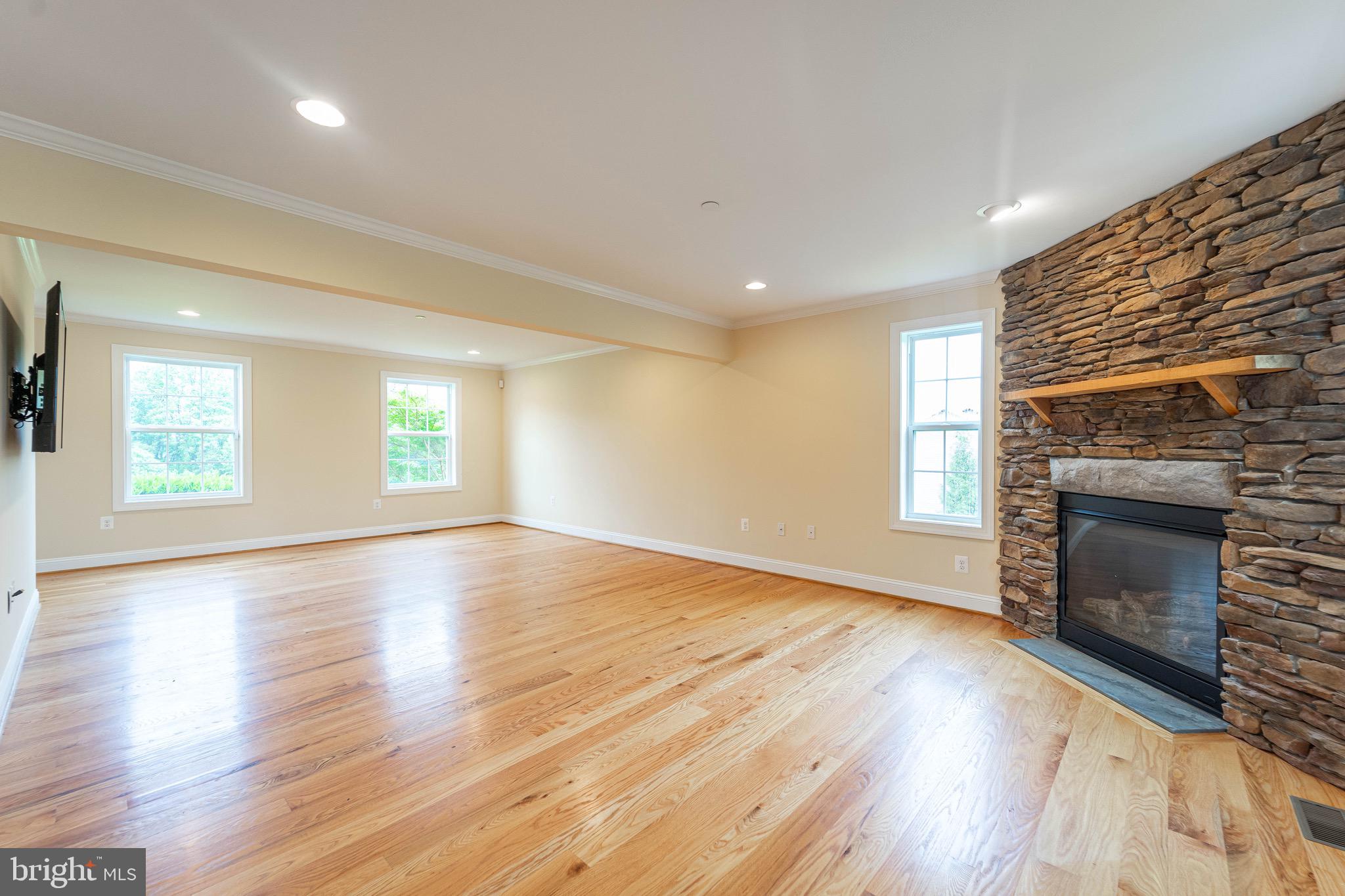 4905 Bartholows Road Mount Airy, MD 21771 - Photo 14 of 70 an empty room with wooden floor fireplace and windows