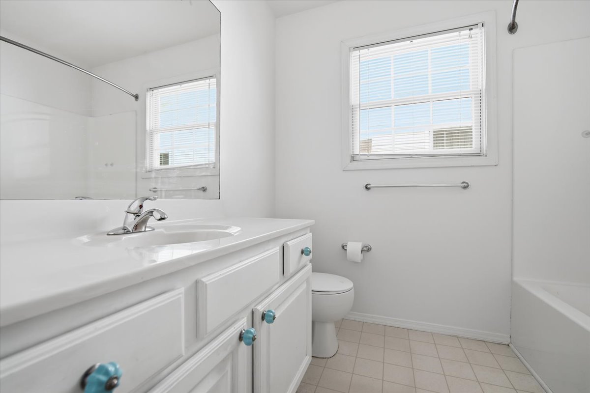 915 Teegan Street Normal, IL 61761 - Photo 18 of 33 a bathroom with a granite countertop sink a toilet and a bathtub