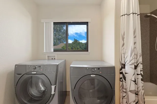 a view of a bathroom with washing machine and a window