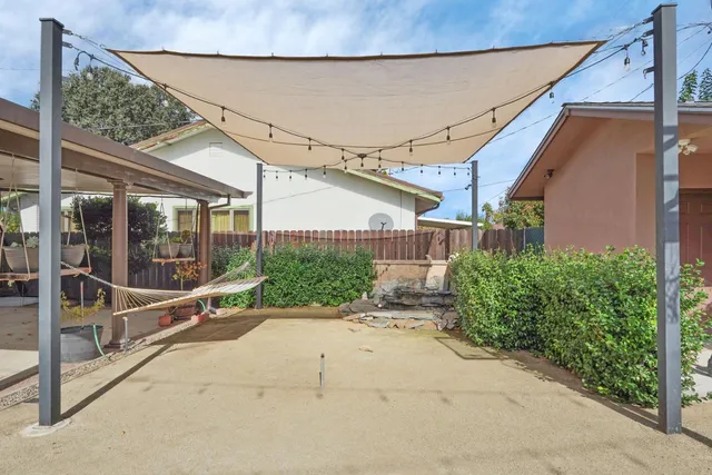 a view of backyard with wheel chair potted plants and wooden fence