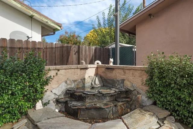 a front view of a house with a garden and trees