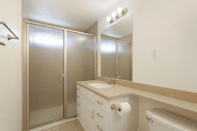 a bathroom with a granite countertop sink toilet and shower