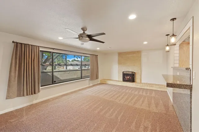 a view of an empty room with a fireplace and a window