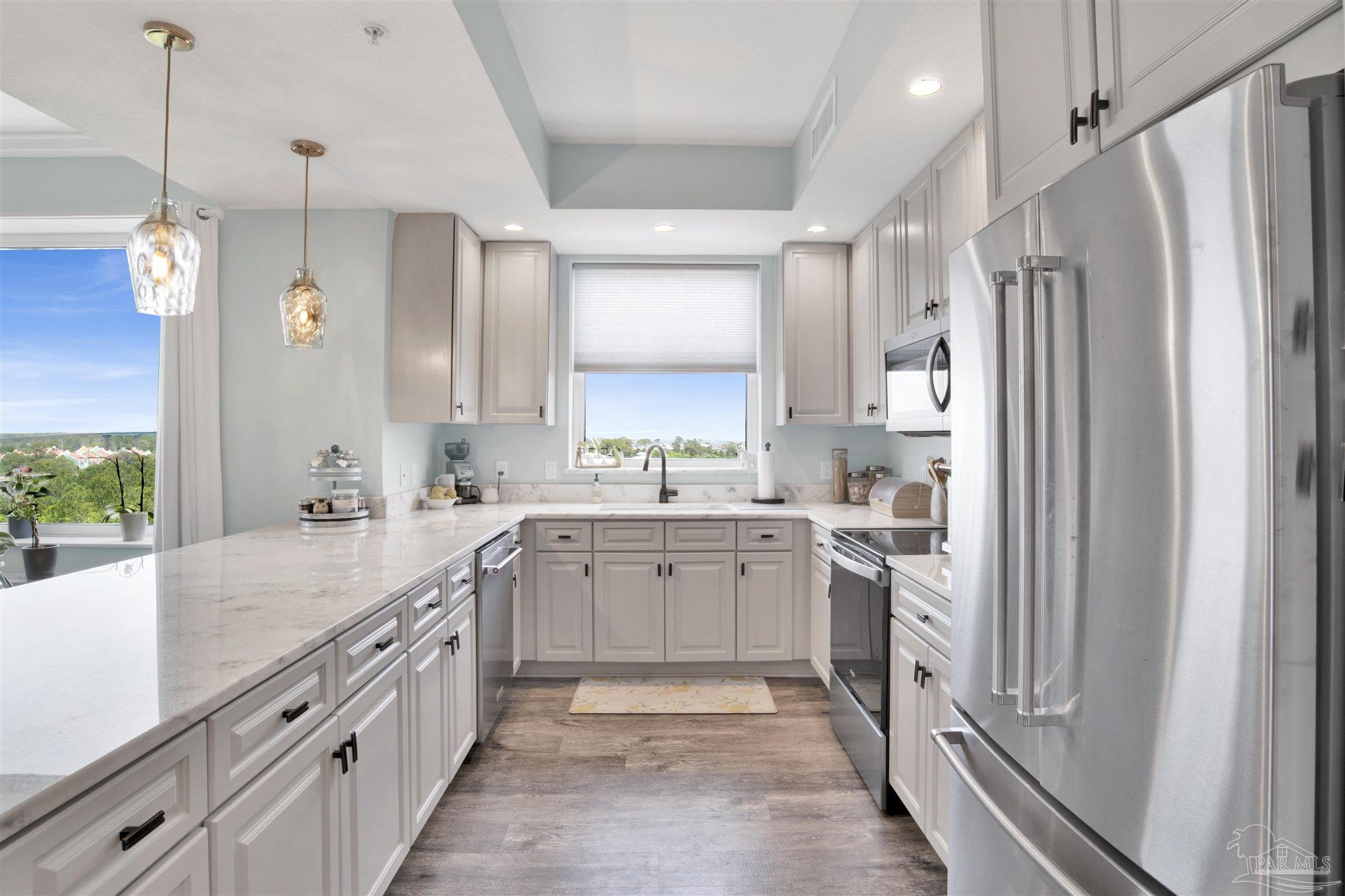 a large kitchen with a sink and refrigerator