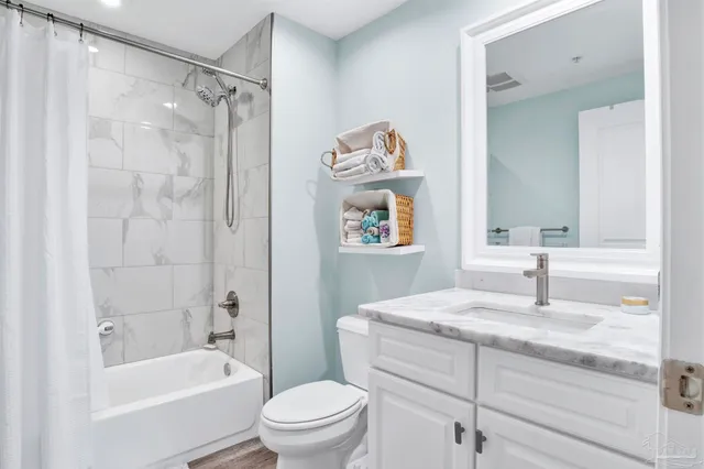 a bathroom with a granite countertop sink a toilet and shower