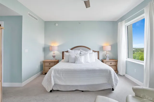 a bedroom with a bed and a large window