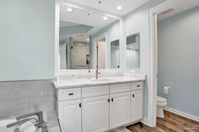 a bathroom with a granite countertop sink mirror and toilet